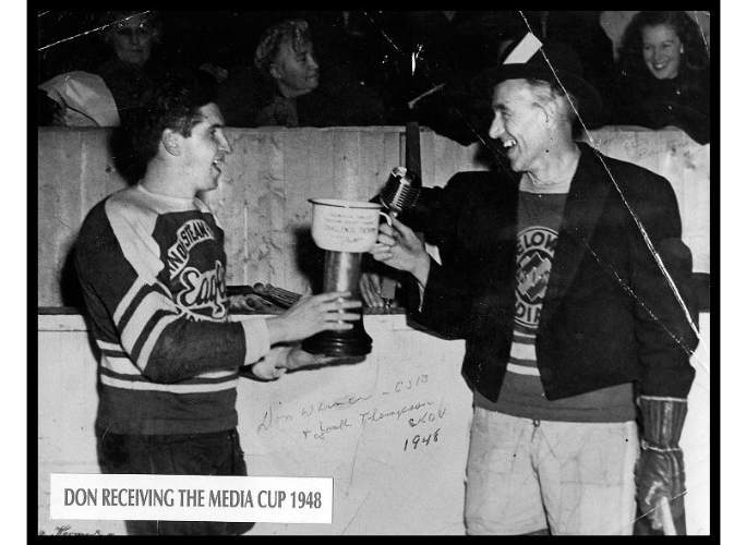 Don Warner receiving the media cup trophy from Jack Thompson in hockey arena, 1948 